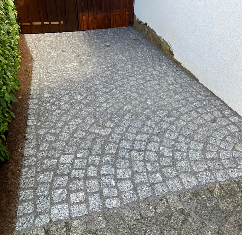 Fertig verlegtes Granit-Kleinpflaster an einer Hofzufahrt